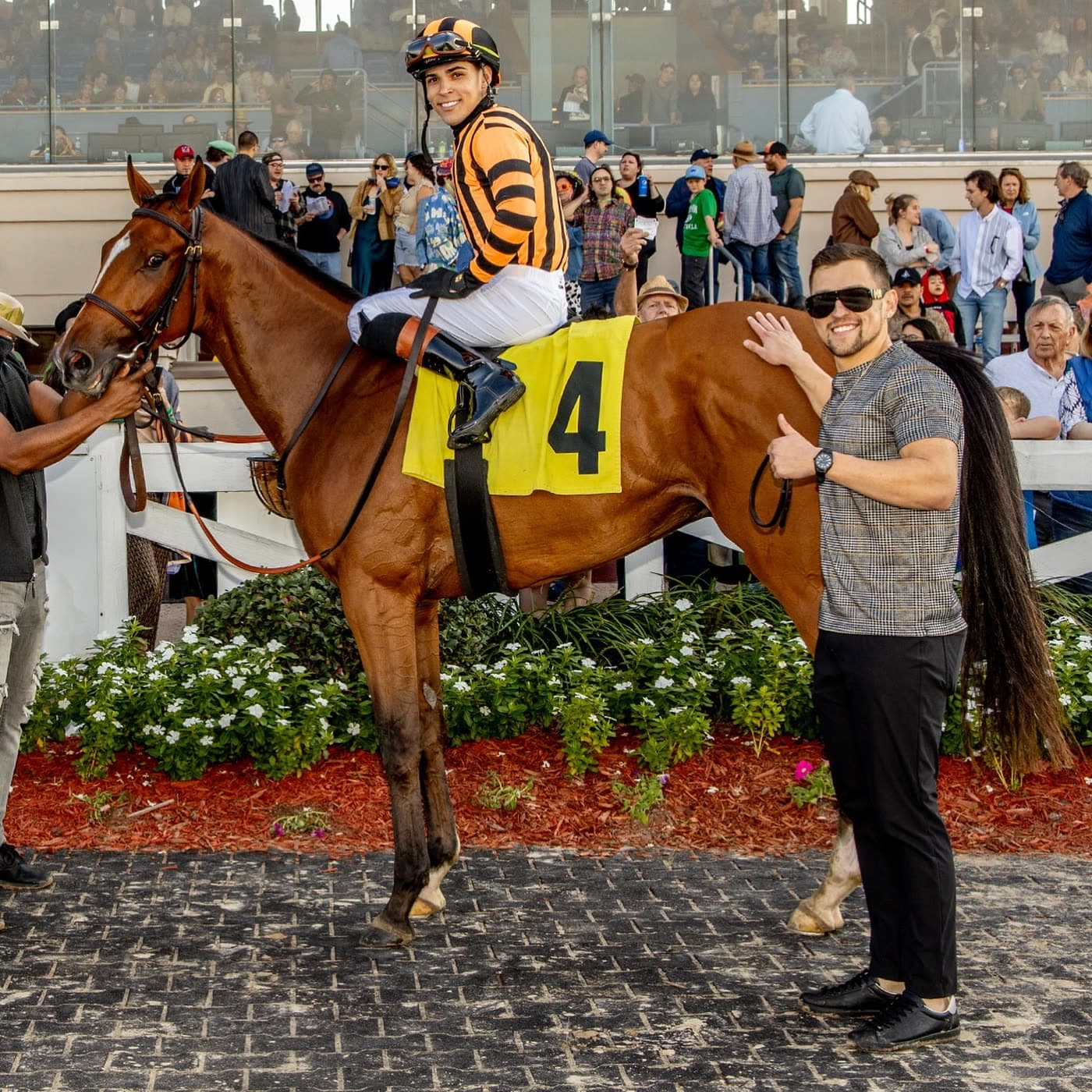 Nick Vaccarezza in the winner's circle, a hand on the horse's shoulder, the jockey still up